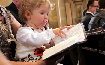 Kind blättert im Gesangbuch